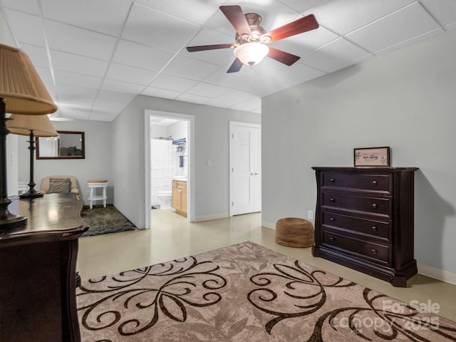 interior space with a drop ceiling, ceiling fan, and ensuite bath