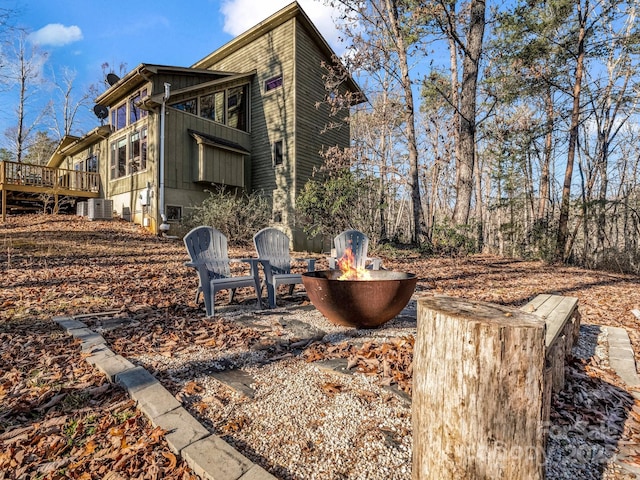 view of patio with a fire pit, central AC unit, and a deck