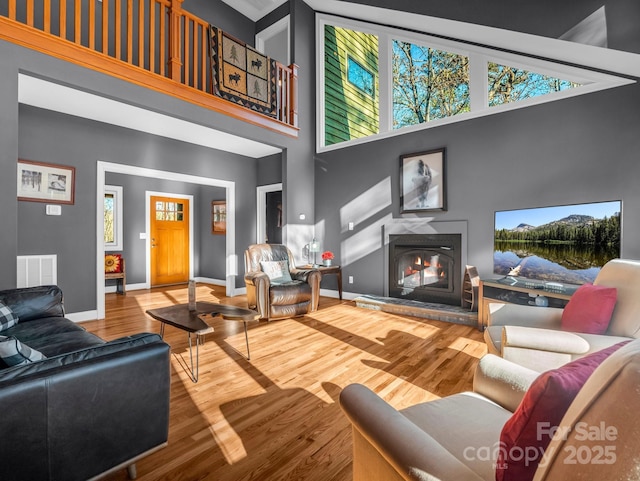 living room with wood-type flooring and high vaulted ceiling