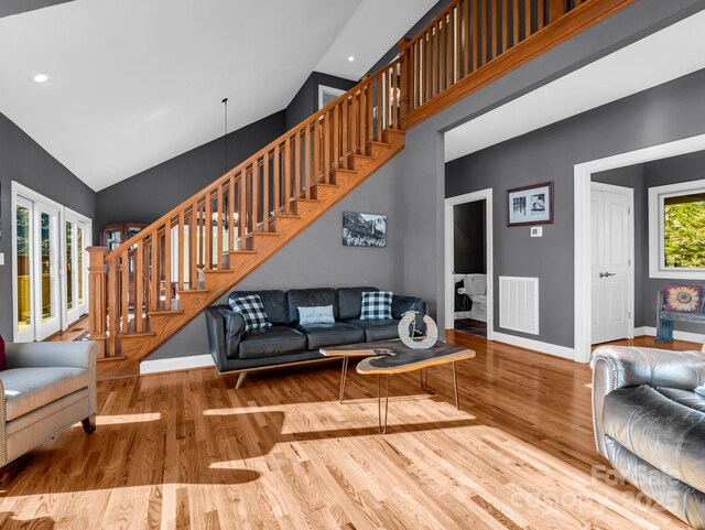 living room with light hardwood / wood-style floors and vaulted ceiling