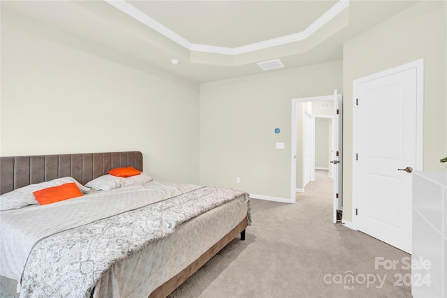 carpeted bedroom featuring a tray ceiling and crown molding