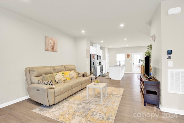 living room featuring sink and light wood-type flooring