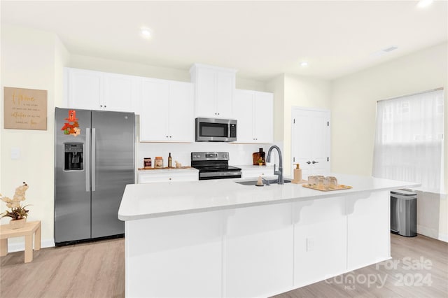 kitchen with white cabinetry, sink, tasteful backsplash, an island with sink, and appliances with stainless steel finishes