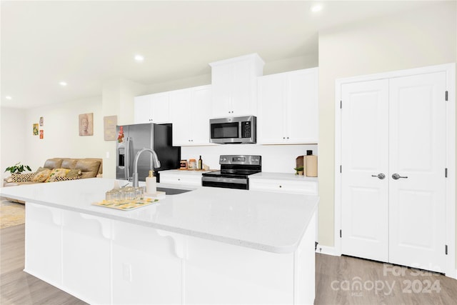 kitchen featuring white cabinetry, sink, an island with sink, and stainless steel appliances