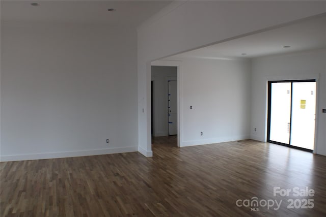 spare room with dark wood-type flooring and ornamental molding