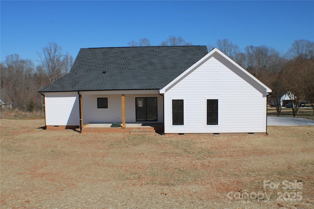 rear view of house with crawl space, a porch, and roof with shingles