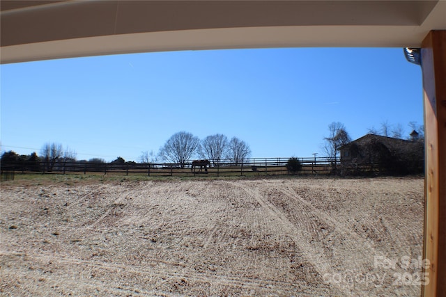 view of yard featuring fence and a rural view