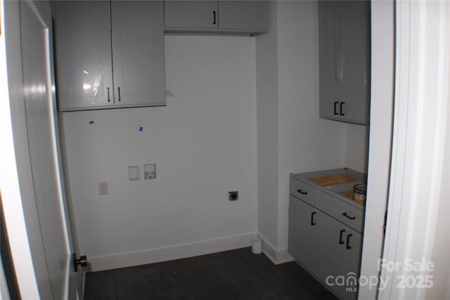 washroom featuring cabinet space, electric dryer hookup, and baseboards