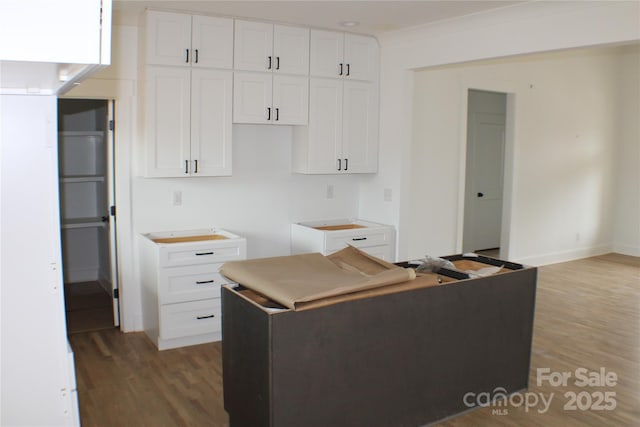 kitchen with baseboards, light wood-style flooring, and white cabinets