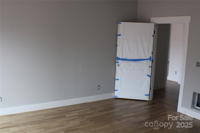 unfurnished room with baseboards and wood finished floors