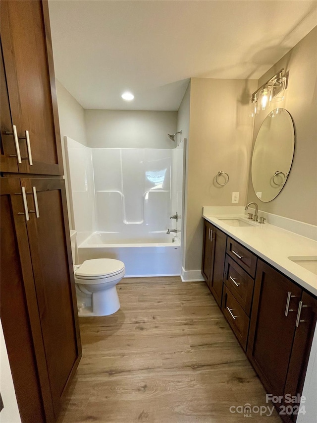 full bathroom with wood-type flooring, vanity, shower / bath combination, and toilet