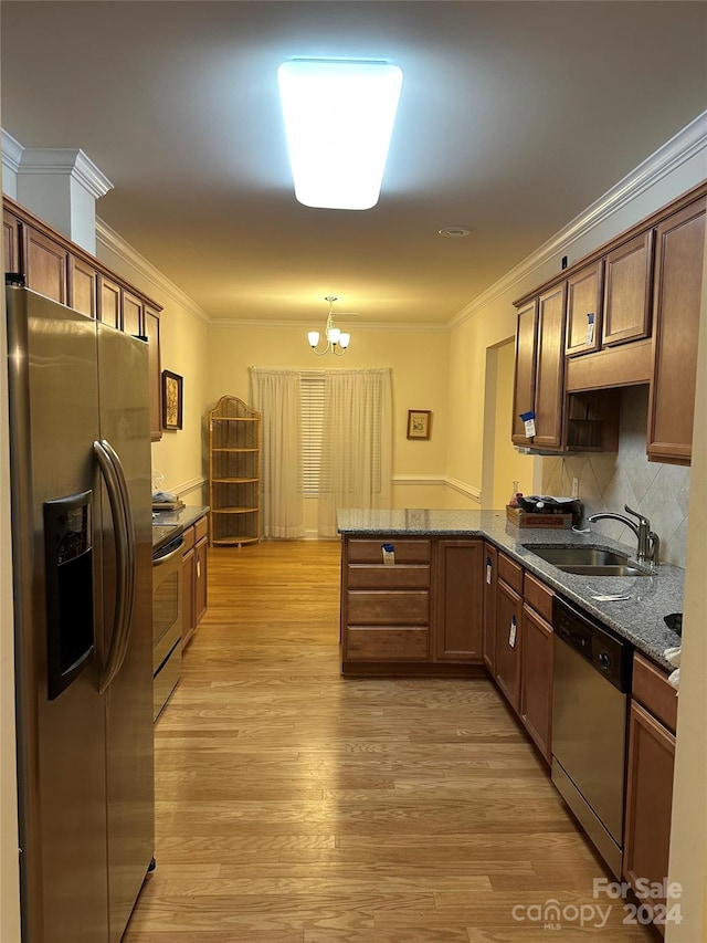 kitchen with an inviting chandelier, sink, light hardwood / wood-style flooring, appliances with stainless steel finishes, and kitchen peninsula