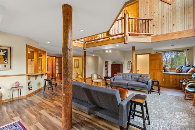 living room featuring a towering ceiling and wood-type flooring