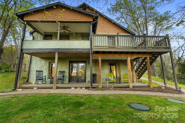 rear view of house featuring ceiling fan, a yard, french doors, and a wooden deck