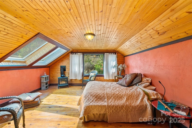 bedroom featuring wooden ceiling, vaulted ceiling with skylight, and light hardwood / wood-style floors