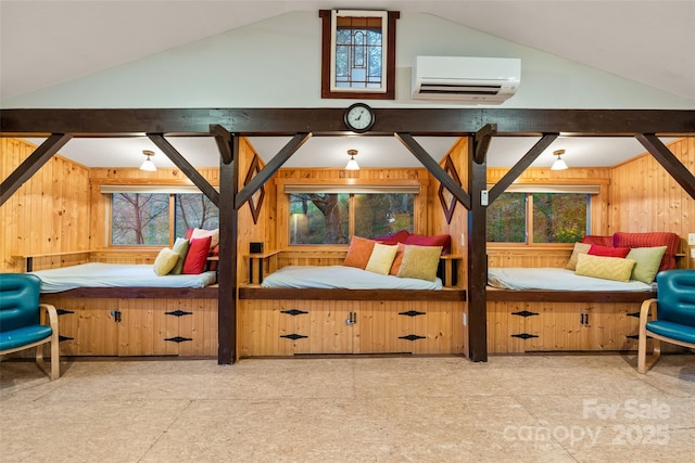 bedroom with vaulted ceiling, wood walls, multiple windows, and a wall unit AC