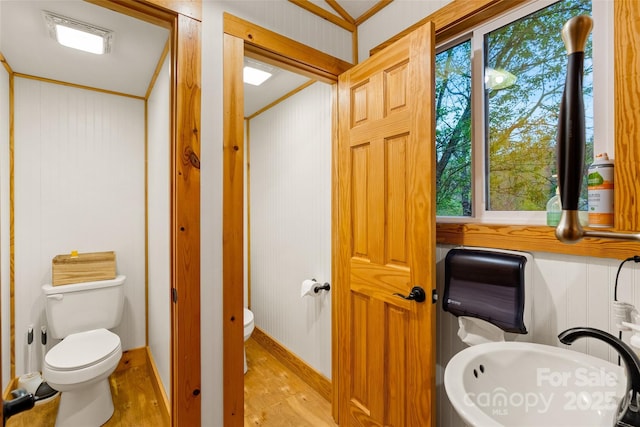 bathroom featuring toilet, ornamental molding, and hardwood / wood-style floors