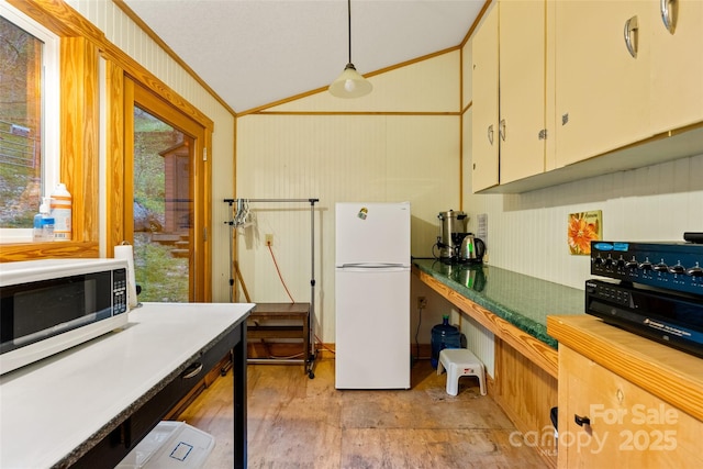 kitchen with decorative light fixtures, vaulted ceiling, white appliances, light wood-type flooring, and ornamental molding