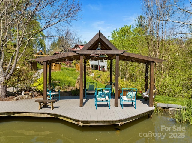 dock area with a gazebo and a deck with water view