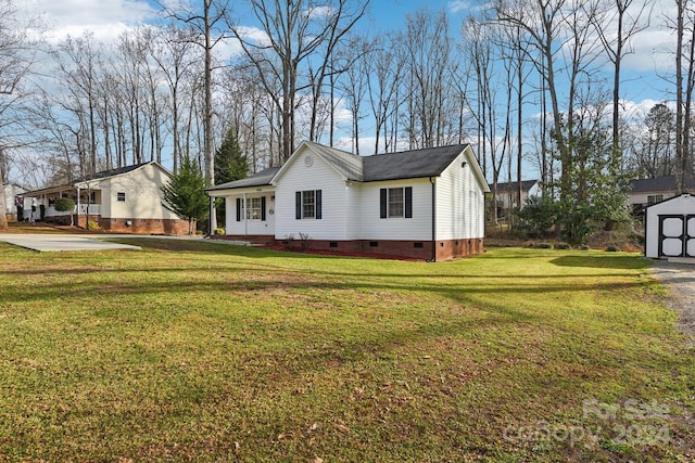 view of front of house with a storage unit and a front lawn