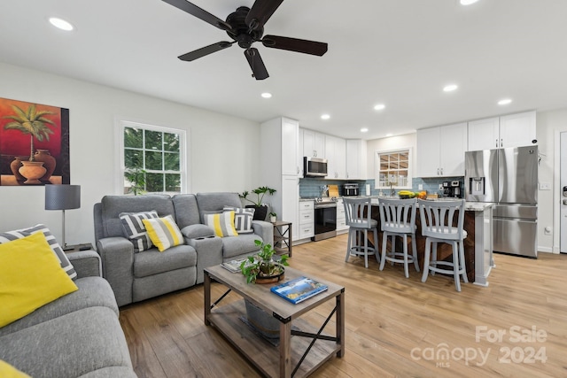 living room featuring ceiling fan and light hardwood / wood-style floors