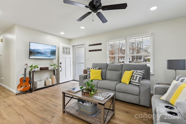 living room featuring light wood-type flooring and ceiling fan