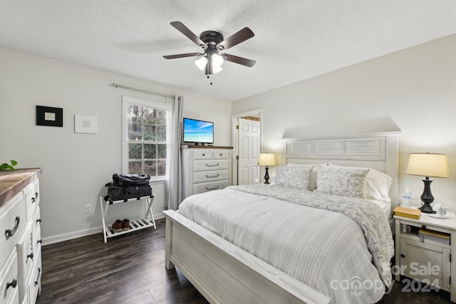 bedroom featuring a textured ceiling, dark hardwood / wood-style floors, and ceiling fan