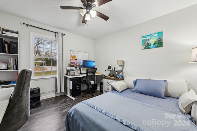 bedroom with a textured ceiling, dark hardwood / wood-style floors, and ceiling fan