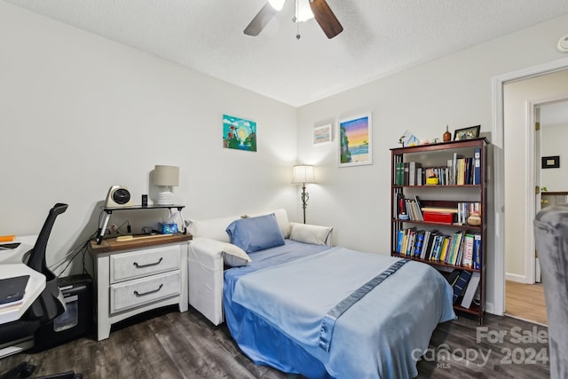 bedroom with a textured ceiling, dark hardwood / wood-style floors, and ceiling fan