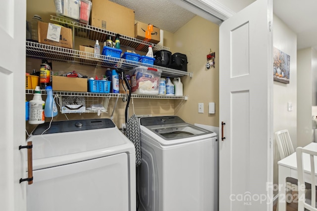 clothes washing area with a textured ceiling and independent washer and dryer