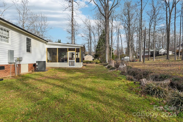 view of yard with a sunroom and central AC unit