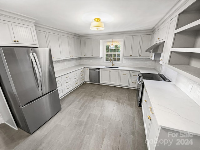 kitchen with decorative backsplash, appliances with stainless steel finishes, light stone counters, sink, and white cabinets