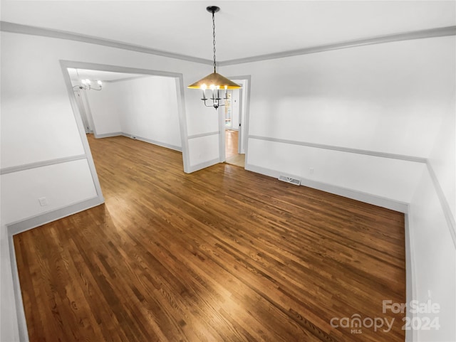 unfurnished dining area featuring hardwood / wood-style flooring and an inviting chandelier