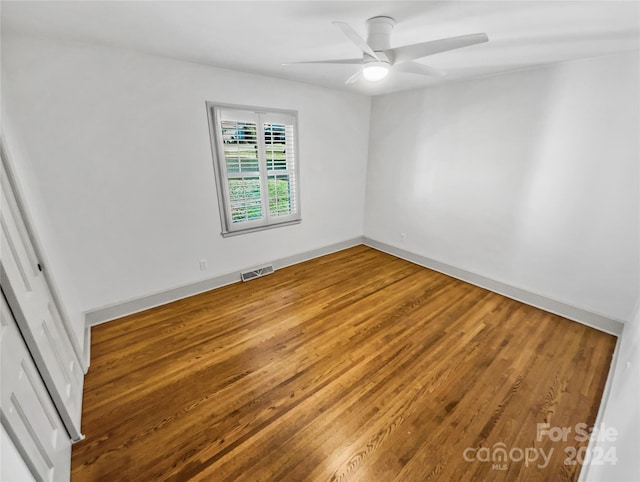 empty room with ceiling fan and hardwood / wood-style floors