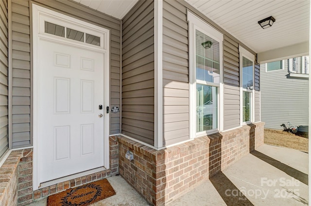 view of exterior entry featuring covered porch