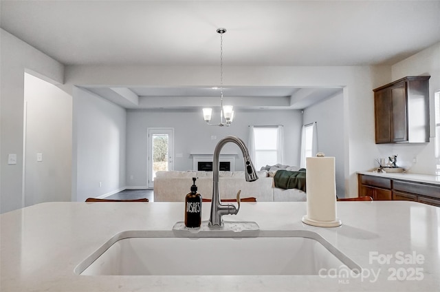 kitchen featuring a chandelier, dark brown cabinetry, decorative light fixtures, and sink