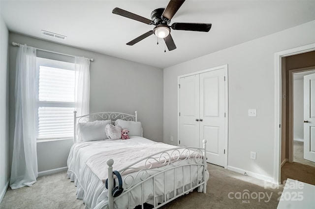 carpeted bedroom featuring multiple windows, ceiling fan, and a closet