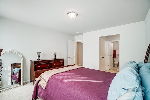 bedroom featuring light carpet and connected bathroom