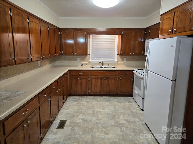 kitchen featuring crown molding, sink, and white appliances