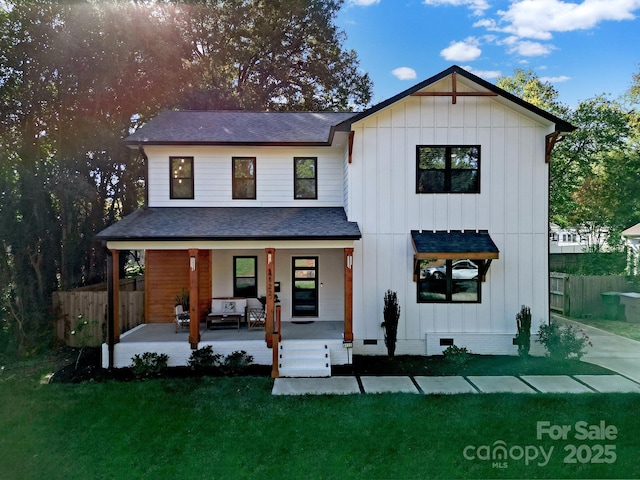 modern farmhouse featuring covered porch and a front yard