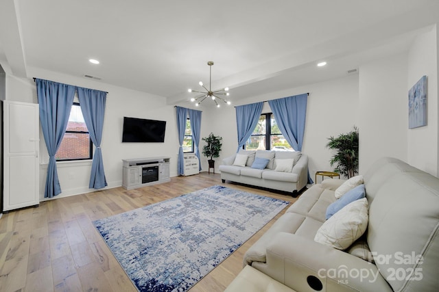 living room with light hardwood / wood-style flooring and a notable chandelier