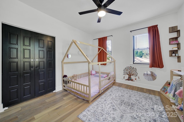 bedroom with hardwood / wood-style floors, ceiling fan, and a closet