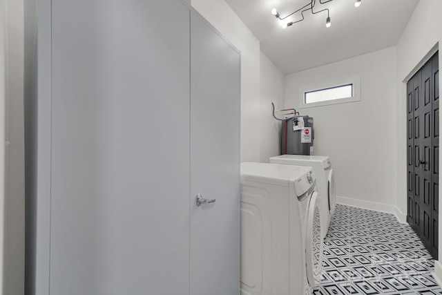 clothes washing area featuring washing machine and dryer and water heater