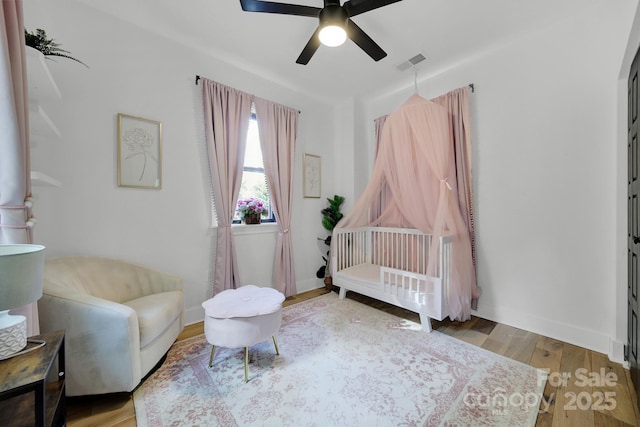 sitting room with ceiling fan and hardwood / wood-style floors