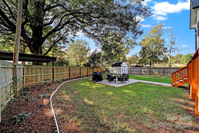 view of yard featuring a storage unit and a patio area