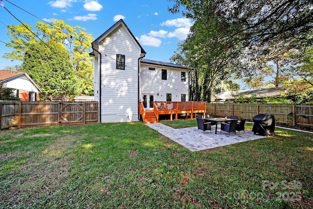 back of property featuring a yard, a deck, and a patio area