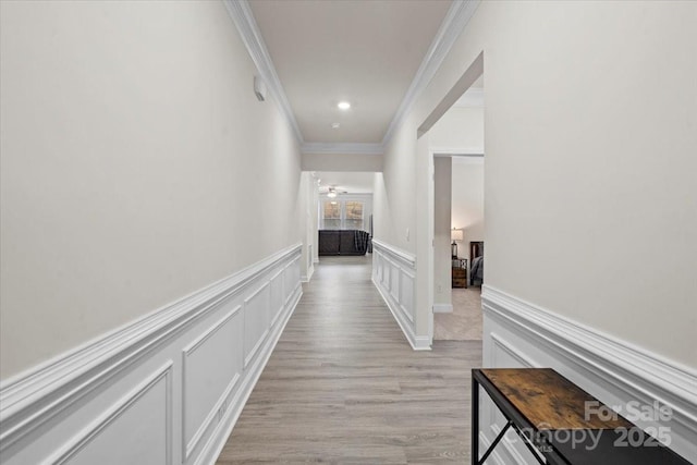 corridor featuring light hardwood / wood-style floors and crown molding