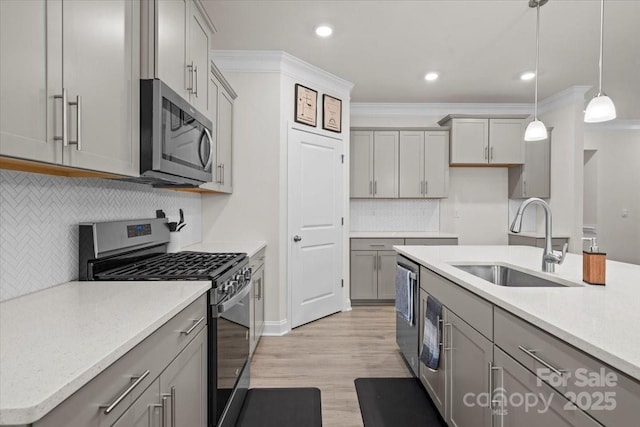 kitchen with decorative backsplash, appliances with stainless steel finishes, decorative light fixtures, and sink