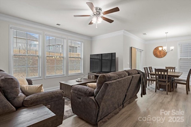 living room featuring light hardwood / wood-style flooring, ceiling fan with notable chandelier, and ornamental molding