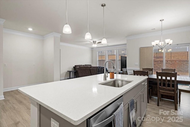 kitchen with sink, decorative light fixtures, a center island with sink, ceiling fan with notable chandelier, and ornamental molding